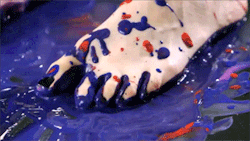 gif: from the video, feet in a mess of paint